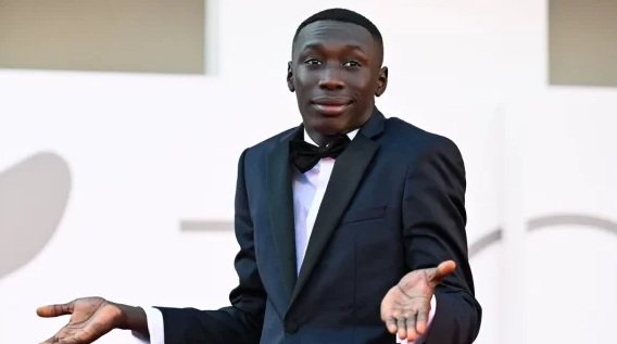 Khaby Lame, influencer senegalés-italiano, realiza su gesto icónico de manos abiertas que lo hizo famoso en TikTok por su humor silencioso y reacciones minimalistas.