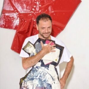 Martín Churba en su taller rodeado de telas y bocetos de diseño textil.